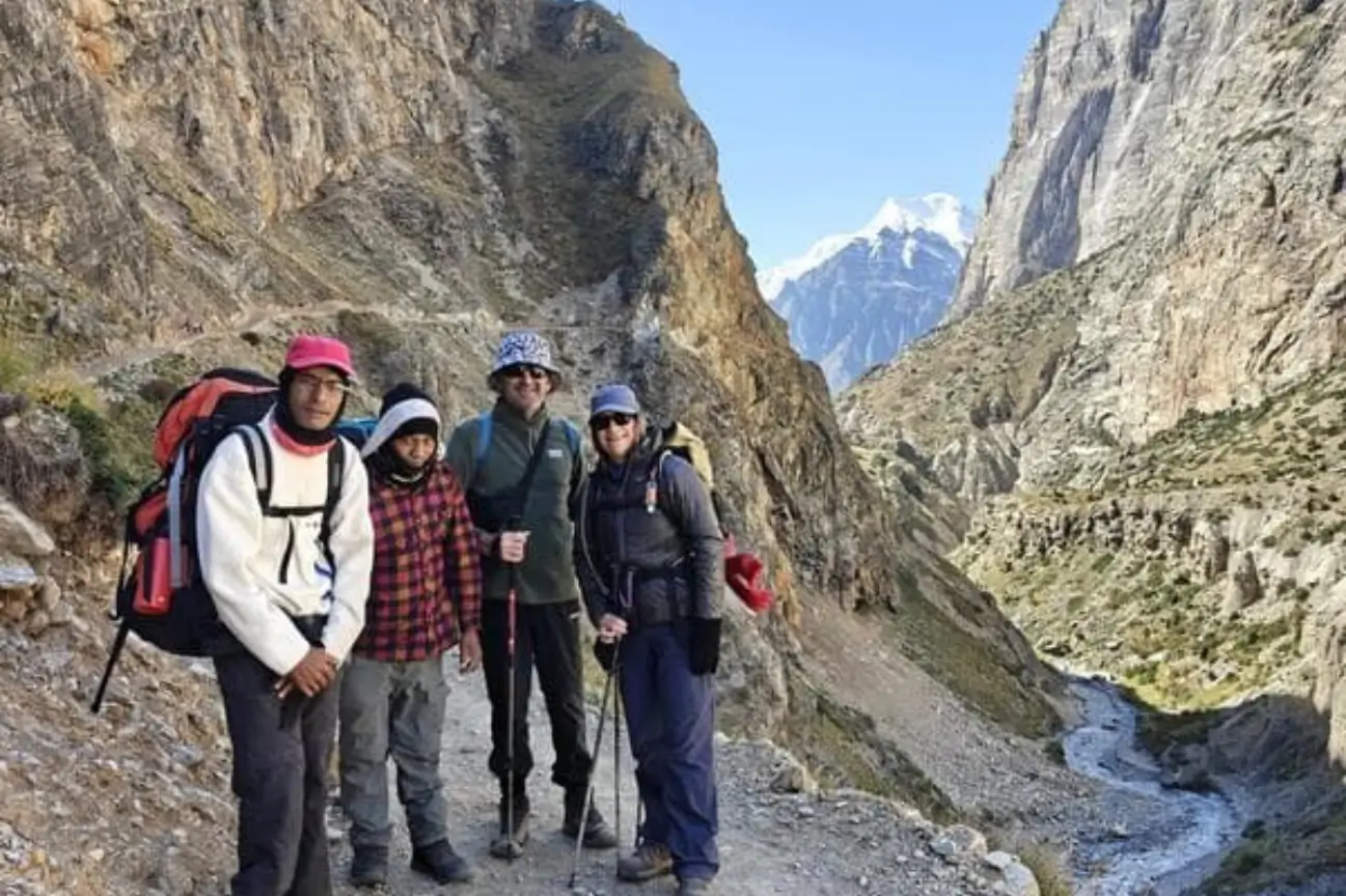 A group of happy trekkers and local guides posing on a mountain trail during a Nepal Trekking Annapurna journey.