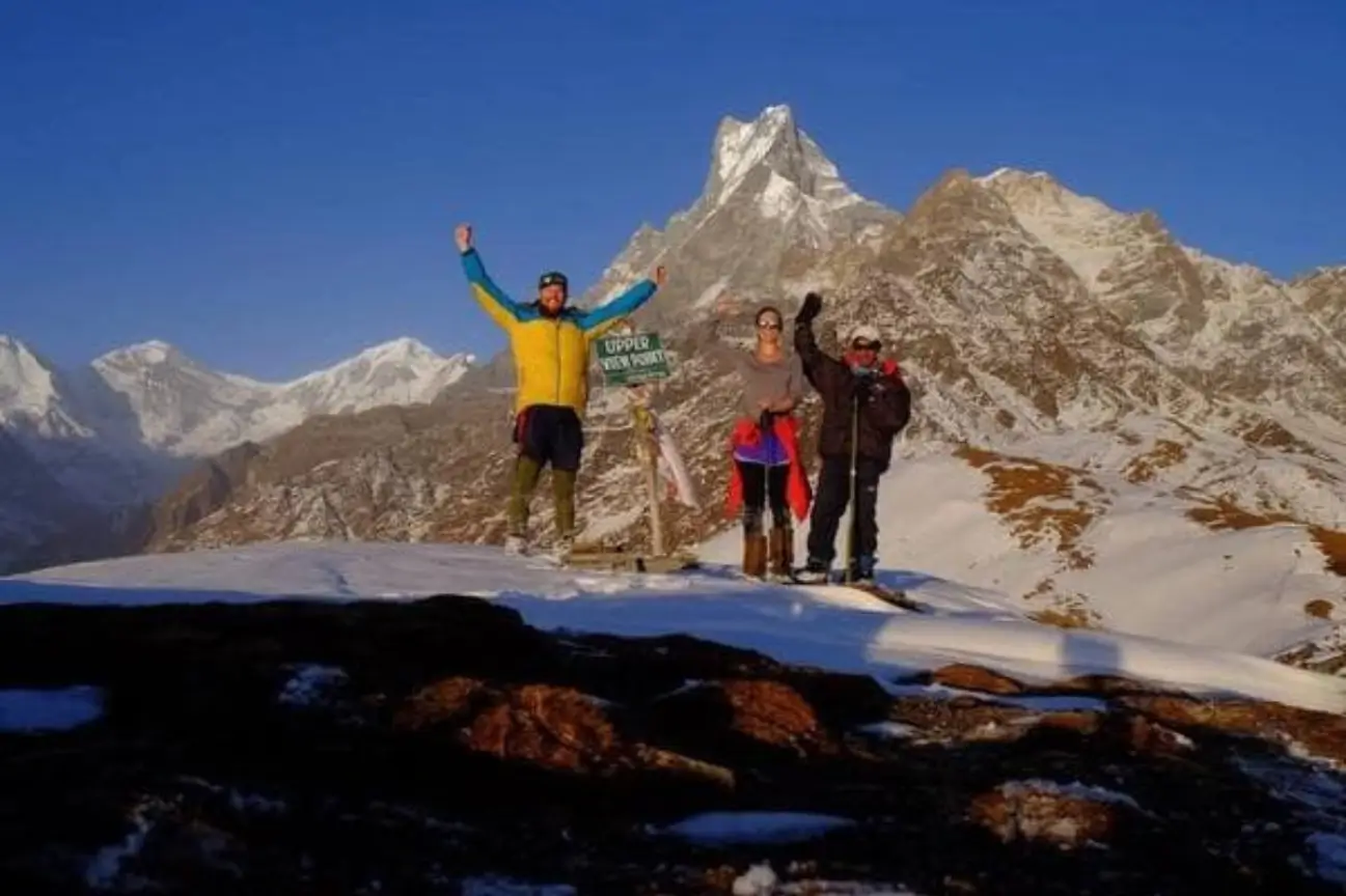 Celebrate Success On Nepal Trekking Annapurna Trekkers celebrating at a snow-covered mountain viewpoint during a classic Nepal Trekking Annapurna journey.
